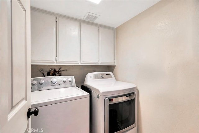 clothes washing area with cabinets and independent washer and dryer