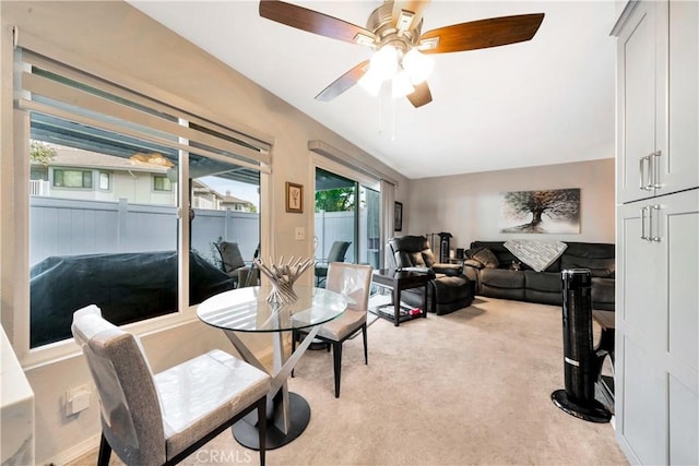 carpeted dining area featuring ceiling fan and lofted ceiling