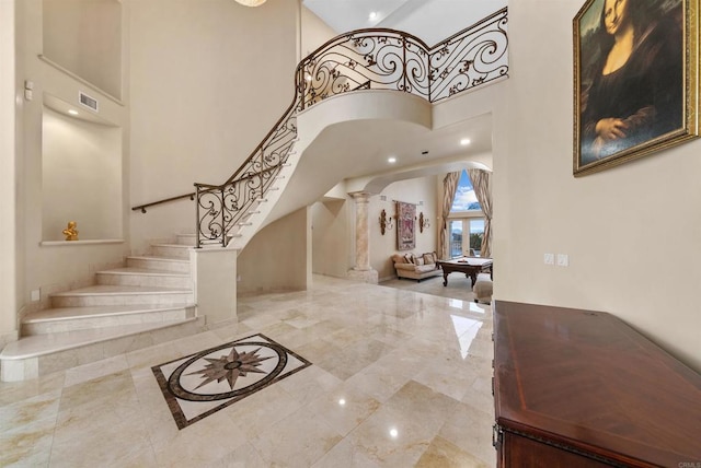 entrance foyer with pool table, ornate columns, and a towering ceiling