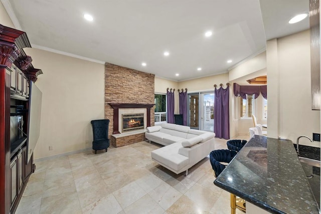 living room featuring crown molding and a stone fireplace