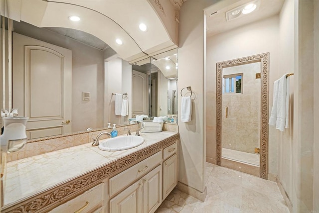 bathroom featuring a shower with shower door and vanity