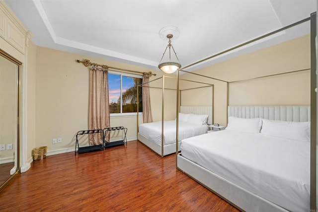 bedroom featuring a raised ceiling and hardwood / wood-style floors