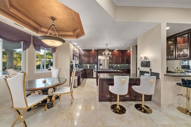 dining area featuring a chandelier, a raised ceiling, and sink