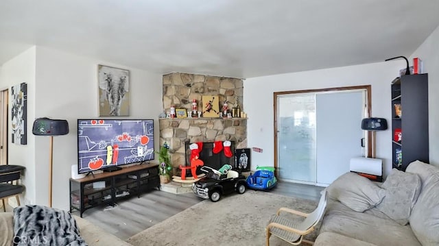 living room featuring a stone fireplace and hardwood / wood-style floors