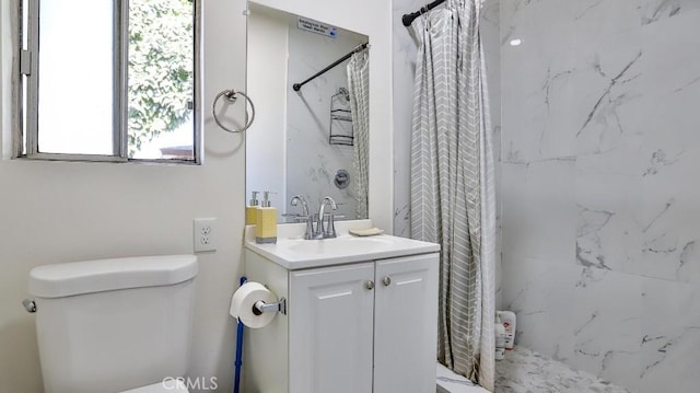 bathroom featuring toilet, vanity, and curtained shower