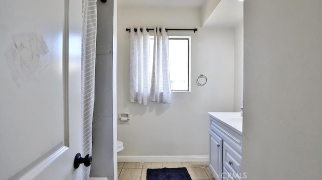 bathroom with toilet, tile patterned flooring, and vanity