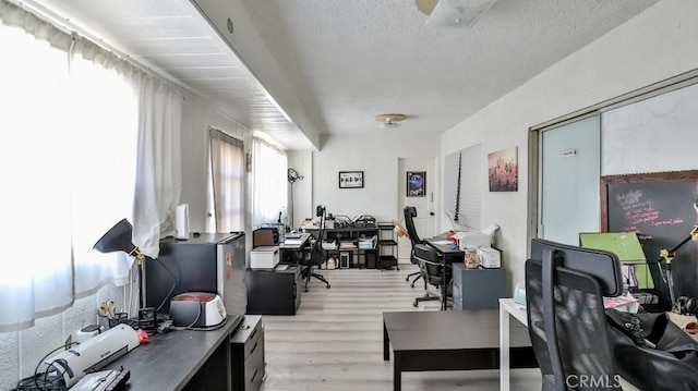 office space with a textured ceiling and light hardwood / wood-style flooring