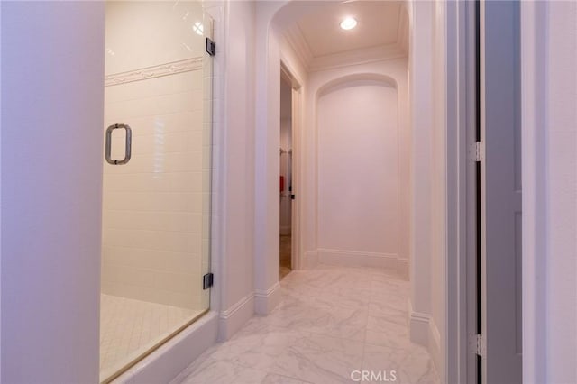 bathroom featuring a shower with door and ornamental molding