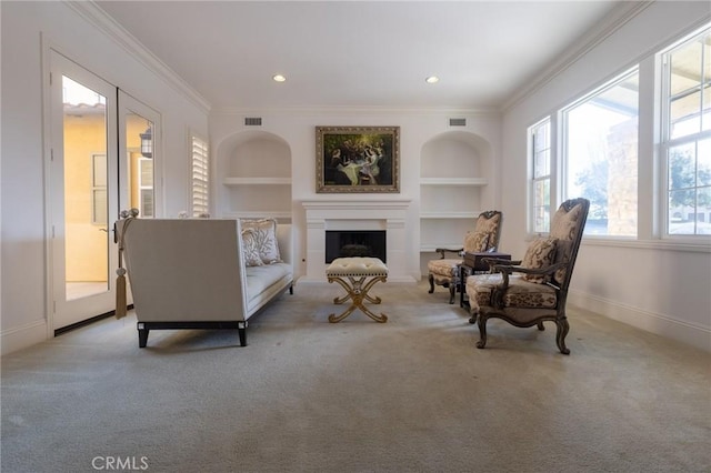 sitting room with light carpet, built in shelves, and ornamental molding