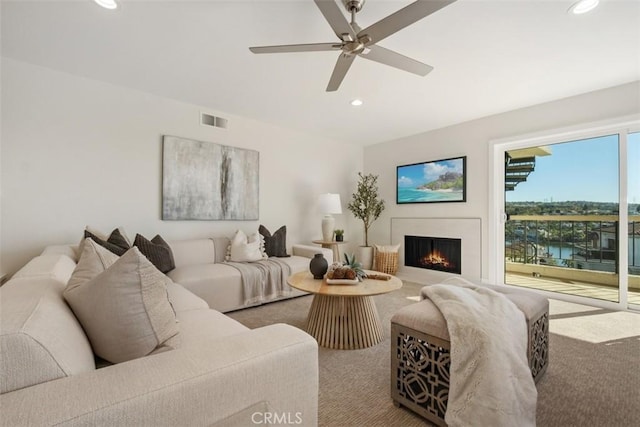 carpeted living room featuring ceiling fan