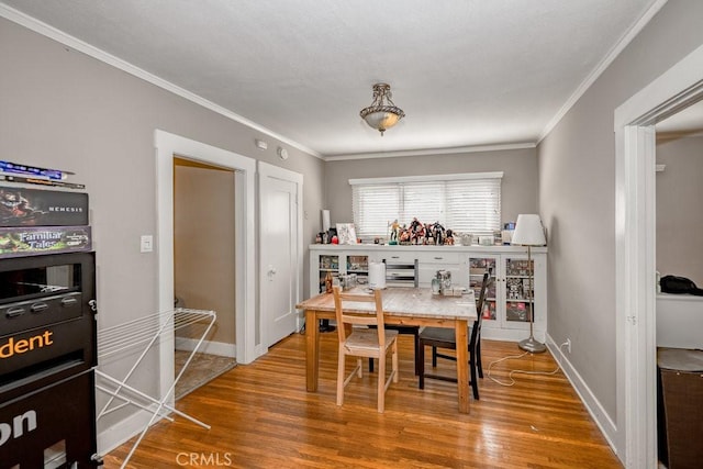 dining space featuring crown molding and hardwood / wood-style floors