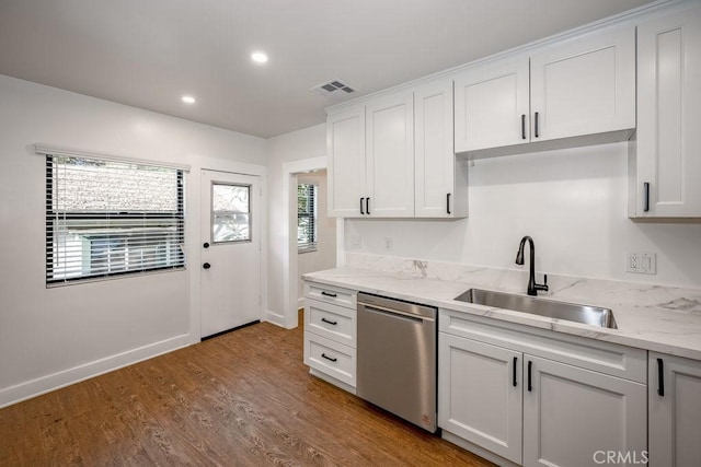 kitchen featuring stainless steel dishwasher, white cabinets, sink, and hardwood / wood-style flooring