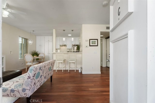 living room featuring dark wood-type flooring and ceiling fan