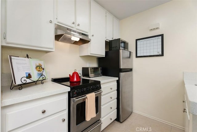 kitchen with light tile patterned floors, stainless steel appliances, and white cabinetry