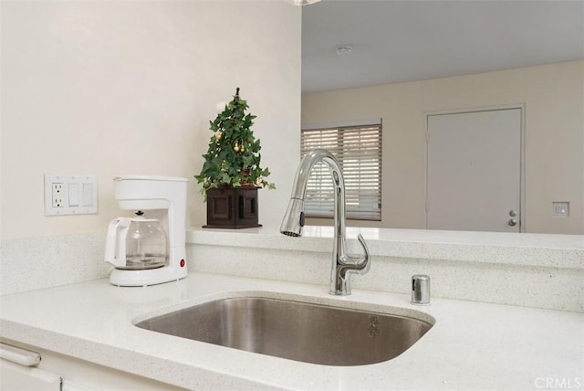 interior details featuring light stone countertops and sink