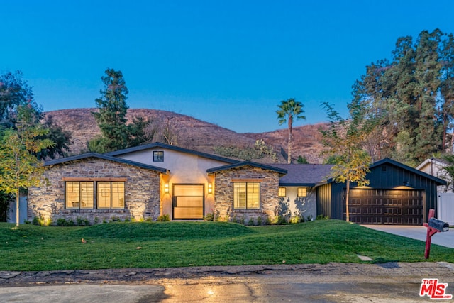 view of front of home with a front lawn, a garage, and a mountain view