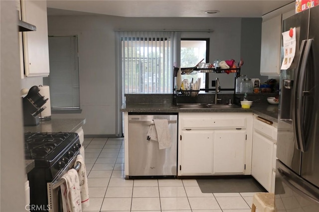 kitchen with light tile patterned flooring, appliances with stainless steel finishes, sink, and white cabinets