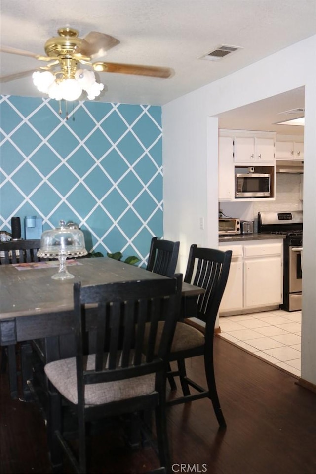 dining area with dark tile patterned flooring and ceiling fan