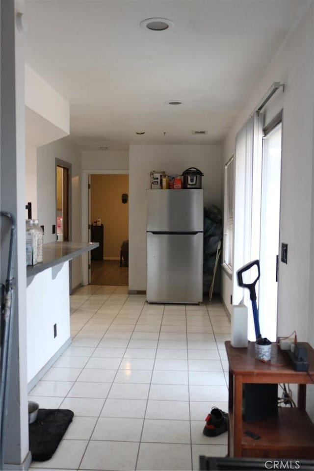 kitchen with stainless steel refrigerator and light tile patterned floors