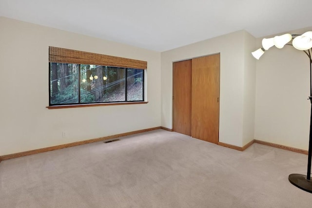 unfurnished bedroom featuring a closet and light colored carpet