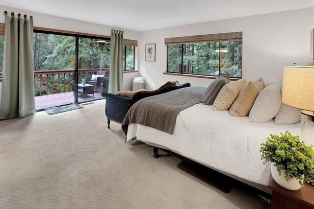 bedroom with light carpet, access to exterior, and multiple windows