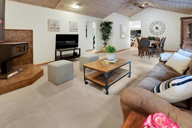 living room with ceiling fan, vaulted ceiling, a wood stove, and wooden ceiling