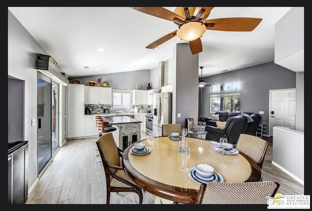 dining room with lofted ceiling and light hardwood / wood-style floors