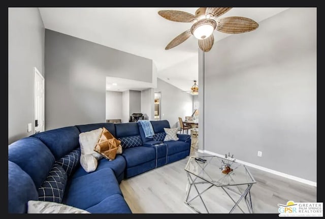 living room featuring ceiling fan, vaulted ceiling, and light hardwood / wood-style flooring