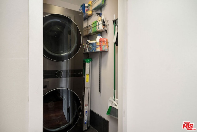 washroom featuring stacked washer / drying machine