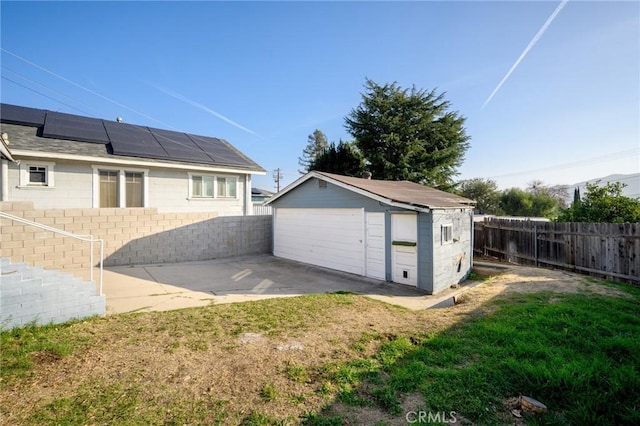 garage with a lawn and solar panels