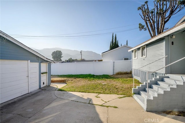 view of yard with a mountain view and a garage