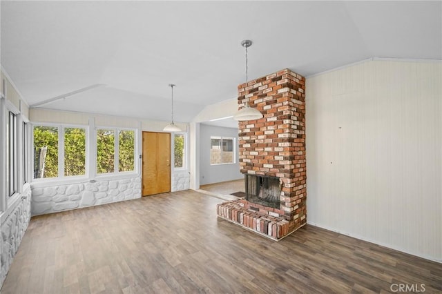 unfurnished living room featuring lofted ceiling, a brick fireplace, crown molding, and hardwood / wood-style floors