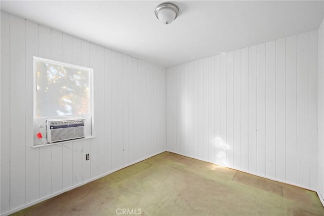 carpeted spare room featuring cooling unit and wood walls