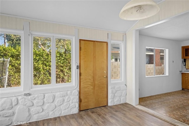 entrance foyer with hardwood / wood-style floors, crown molding, and vaulted ceiling