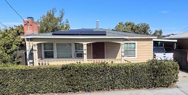 view of front facade featuring covered porch and solar panels