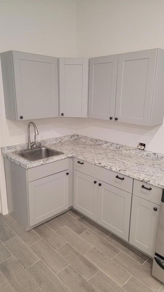 kitchen featuring light stone counters and sink