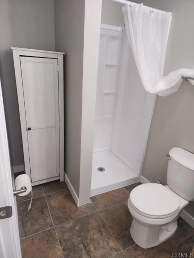 bathroom featuring toilet and a shower with shower curtain