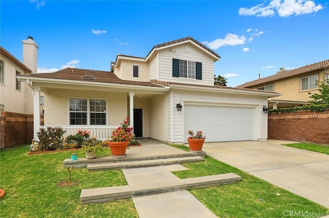 view of property featuring a garage, a front yard, and a porch