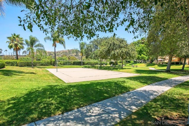 view of home's community with volleyball court and a lawn