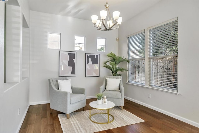 living area featuring dark wood-type flooring and a chandelier