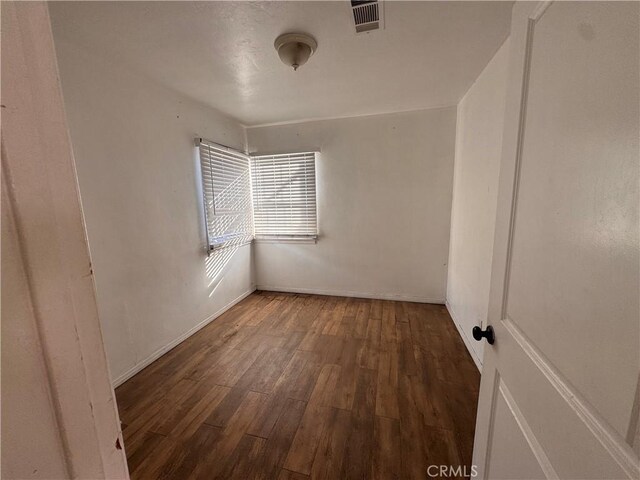 unfurnished room featuring dark hardwood / wood-style flooring