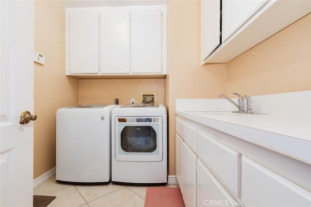 laundry room featuring sink, light tile patterned flooring, separate washer and dryer, and cabinets