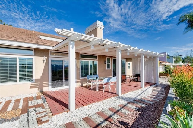 back of property with a pergola and a wooden deck