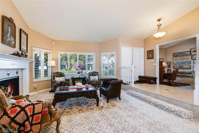 living room featuring vaulted ceiling and a tile fireplace