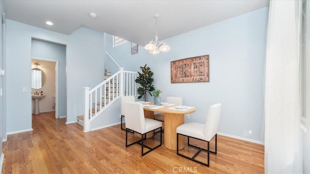 dining area with sink, a chandelier, and hardwood / wood-style floors