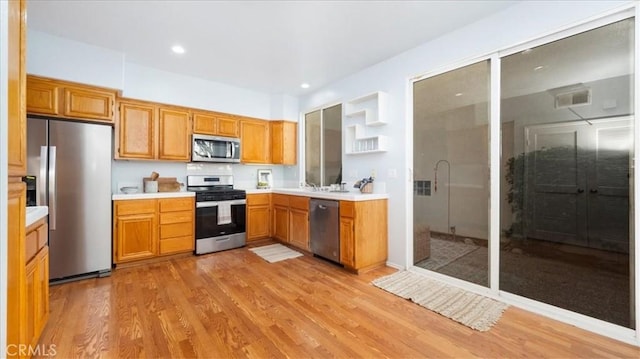 kitchen with light wood-type flooring and appliances with stainless steel finishes