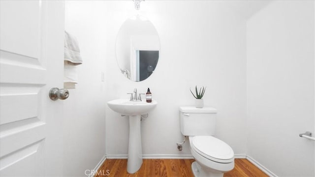 bathroom with toilet and hardwood / wood-style flooring