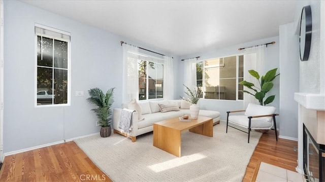 sitting room featuring a tiled fireplace and light hardwood / wood-style flooring