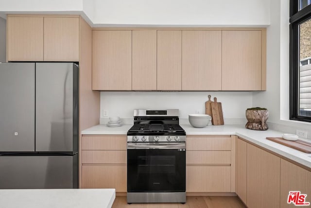 kitchen featuring stainless steel appliances and light brown cabinets