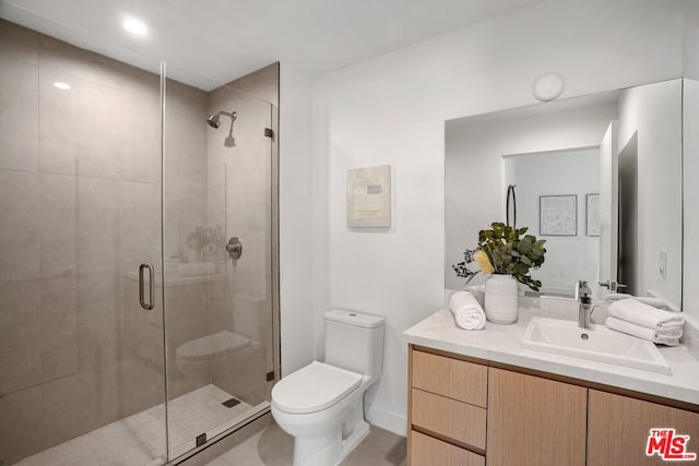 bathroom featuring a shower with shower door, toilet, and vanity